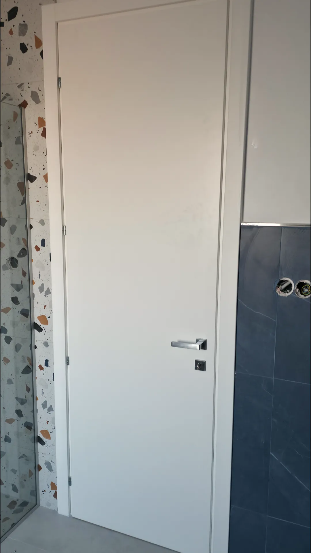Porta interna bianca a filo su parete scura