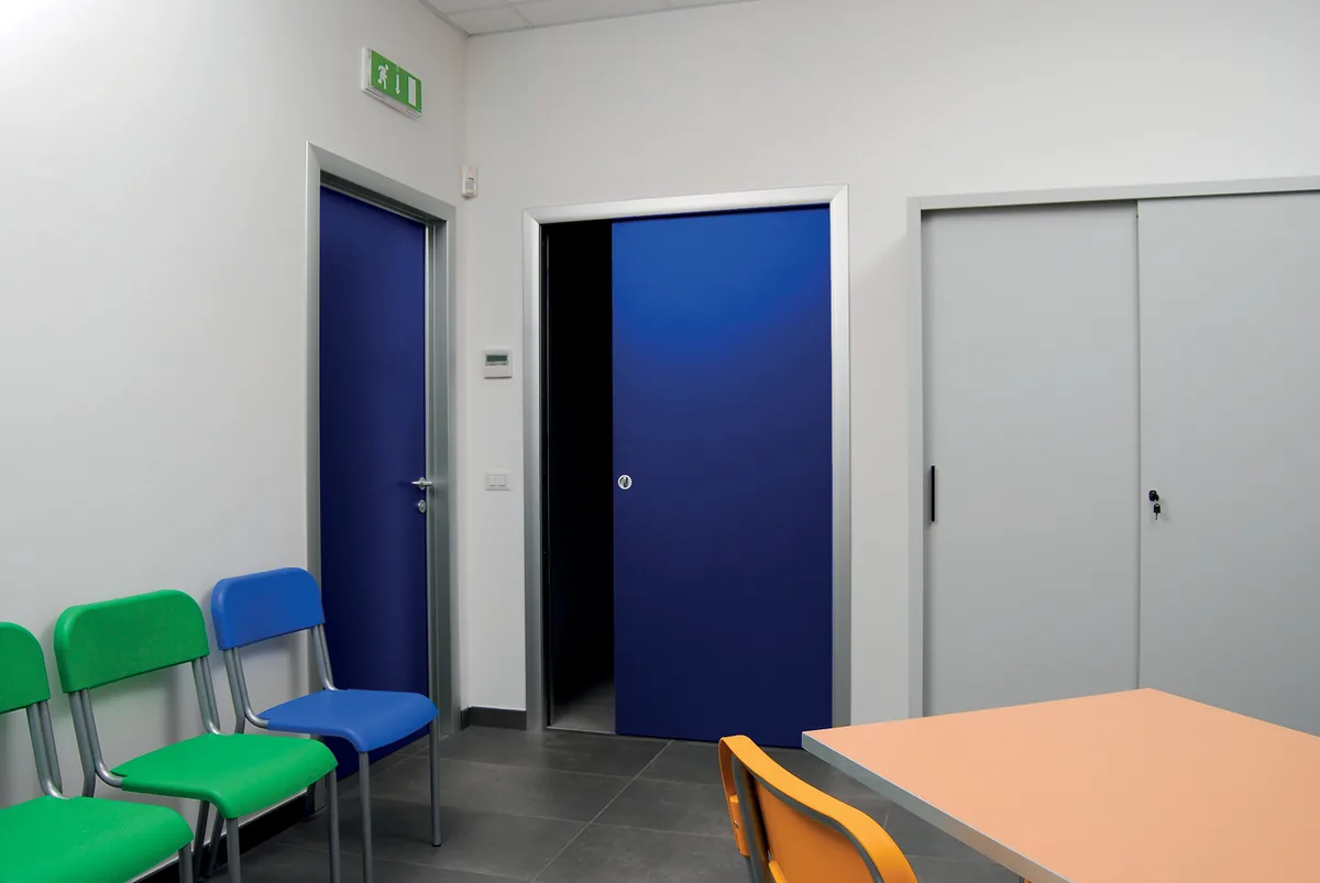 Sala d&rsquo;attesa di un ambulatorio con porte colorate